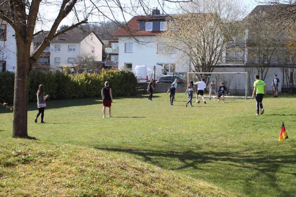 Kinder und Jugendliche spielen Fußball auf dem Fußballplatz der ESTA