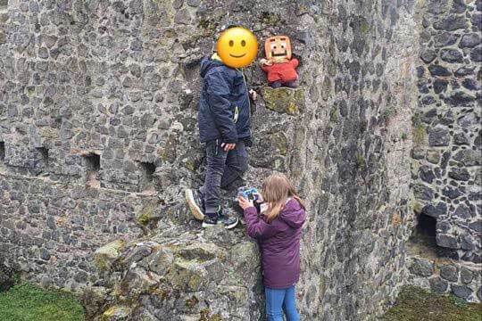 Zwei Kinder stehen an einer Steinwand der Münzenburg