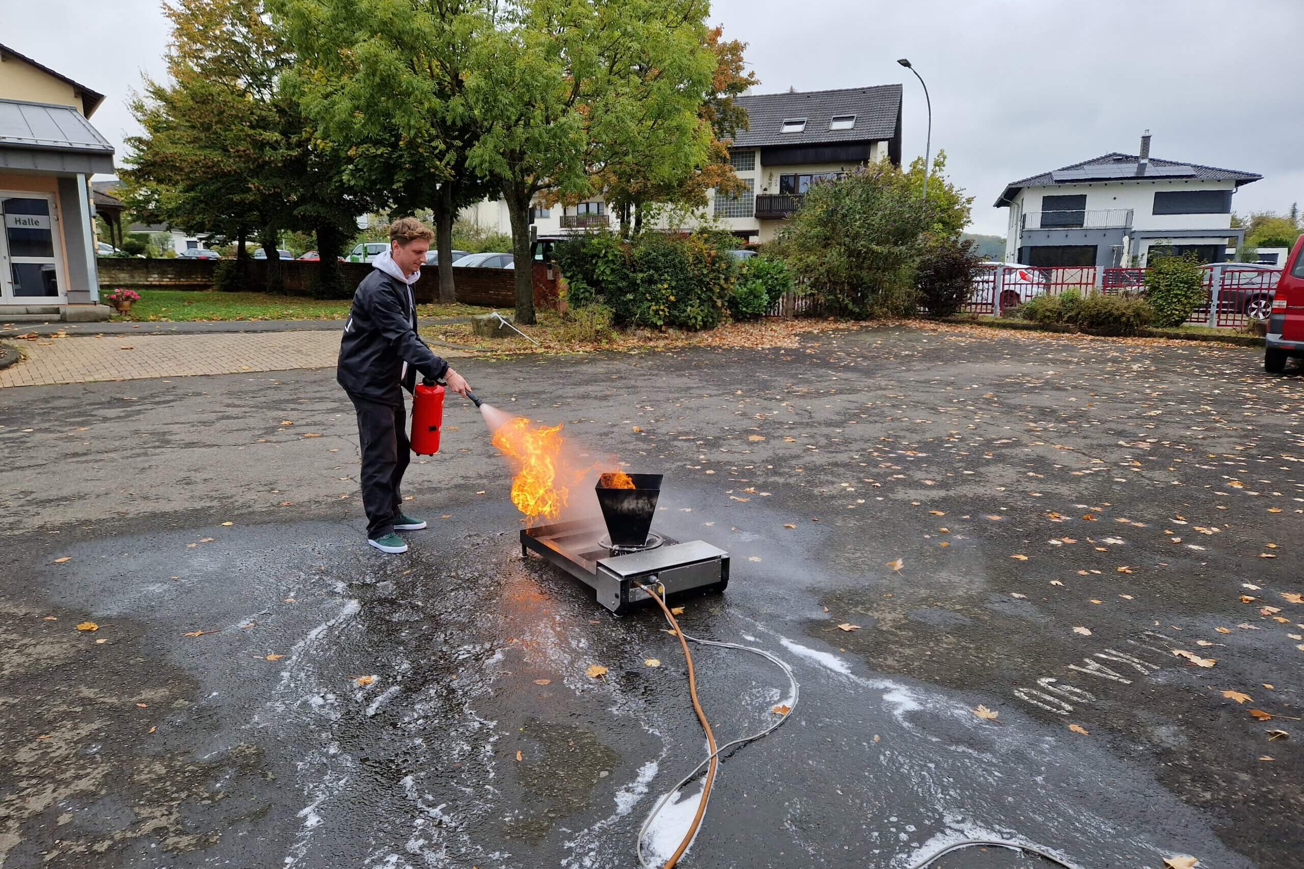 Unser Pädagoge löscht Feuer mit einem Feuerlöscher