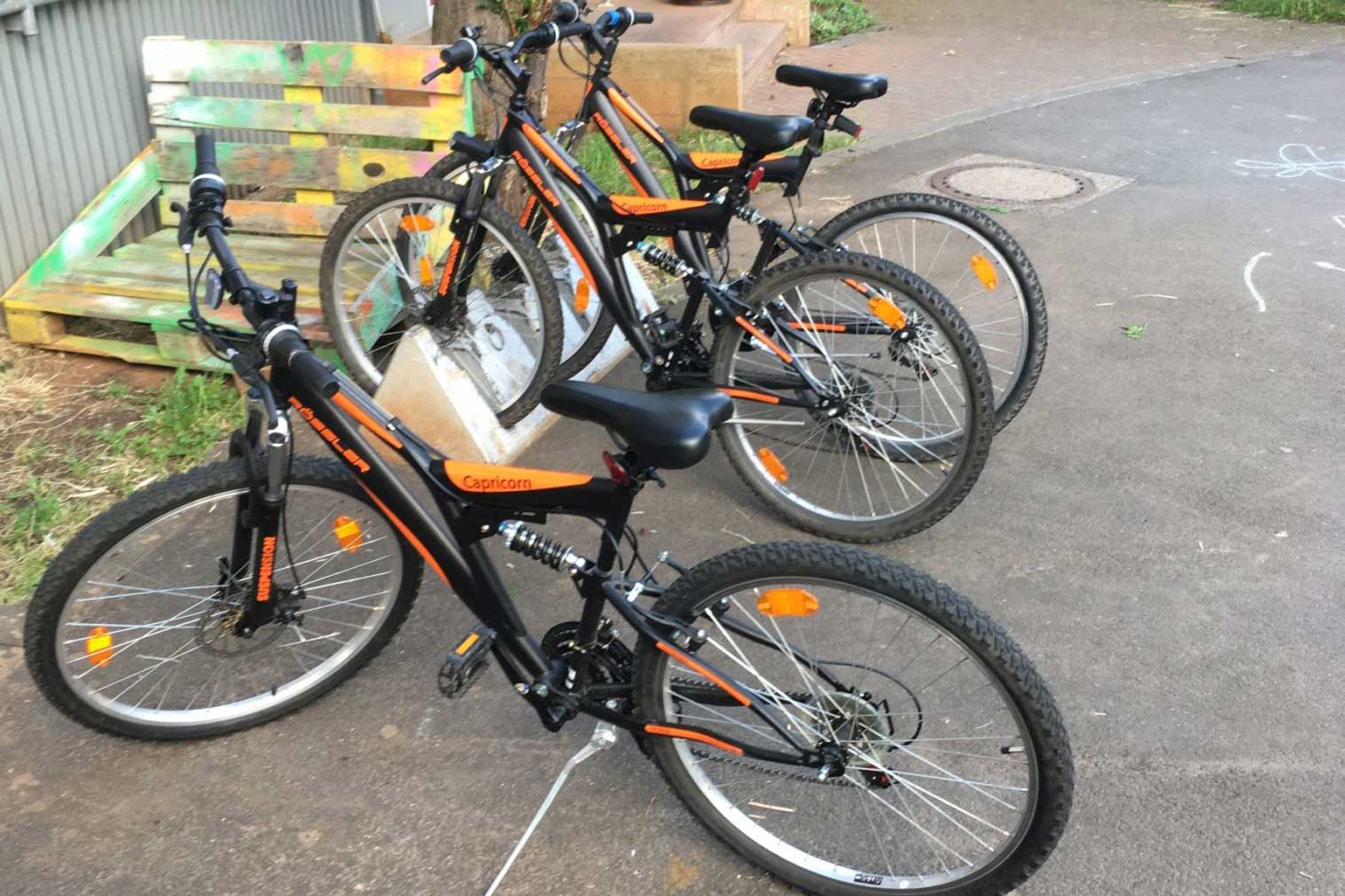Drei schwarz-orange Mountainbikes am Fahrradständer der ESTA