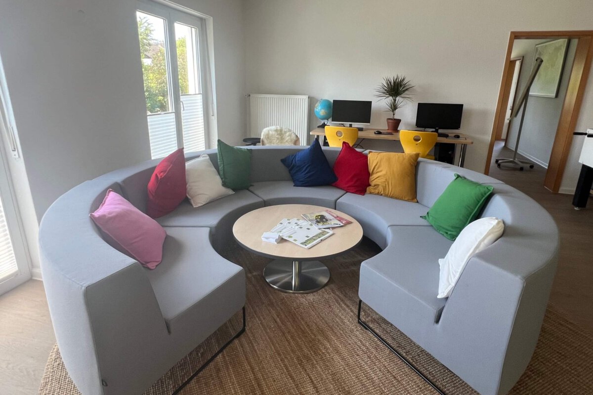 Graues halbrundes Sofa mit bunten Kissen